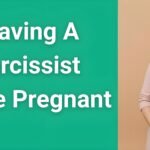 Pregnant woman looking hopeful while holding hands over belly, representing the courage of leaving a narcissist while pregnant for her baby's future